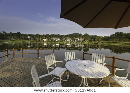 Flamingo Dai Lai, Vinh Phuc province, Vietnam - October 13, 2016 : table and chairs on wooden pier on shore of lake in summer landscape at Flamingo resort Dai Lai, Vietnam