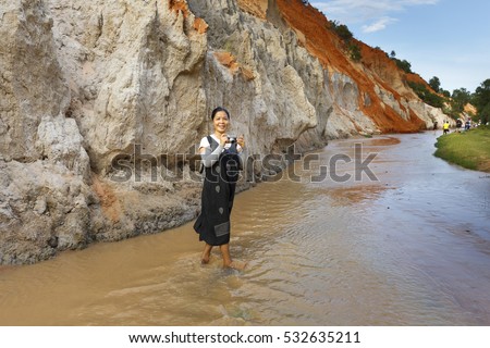 Mui Ne, Phan Thiet city, Vietnam - November 27, 2016 : Woman so excited to be walking on feet in the Red Stream ( it also named Fairy Stream) located near the beach of Mui Ne, Binh Thuan Province