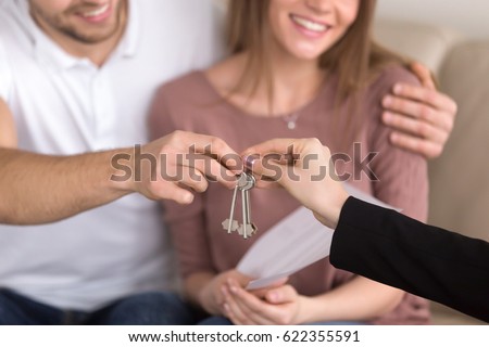 Close Up Of Happy Couple Getting Keys To Their New House Hand A Female Close Up Of Happy Couple Getting Keys To Their New House Hand A Female