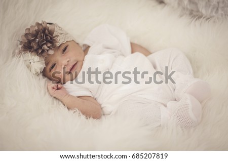 portrait of cute and adorable newborn baby with head band on furry mat.motherhood and parenting concept.