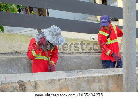 Muadzam Shah, Malaysia - March 22nd, 2018: Municipal workers "Alam Flora" uses sweepers and shovels to clean the garbage in the drain and put into the garbage bag.