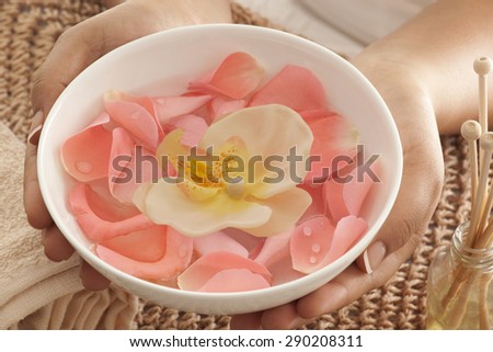Rose petals and orchid in a bowl with reed diffuser