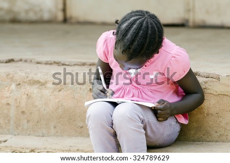 Close-Up of African Little Black Girl Writing notes sitting outside of her school building (classroom). Education schooling symbol.