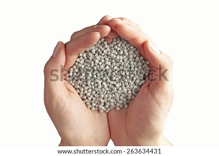 Hands filled with chemical granules isolated on white. Clipping path included
