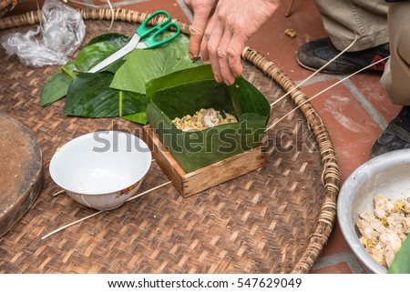 Hand stuffing Chung Cake in square shape with glutinous rice, split mung beans, chunks of pork shoulder, salt, pepper, ginger. It is packed as tight as possible to keep cake from mold or spoiled.