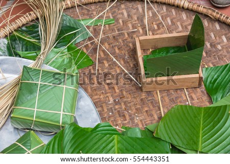 Chung Cake ingredients, tool preparation wrapping. Square shape wood mold with glutinous rice, split mung beans, chunks of pork shoulder, salt, pepper, ginger, bamboo, banana leaves, long node string.