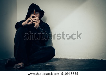 overdose asian male drug addict.narcotic syringe on hand.