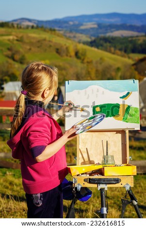 little painter at work in the mountains with palette