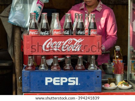 Phnom Penh, Cambodia- January 02, 2014. Coca-Cola and Pepsi bottles stacked in plastic container - vintage style. Symbolic representation of one of the greatest business rivalries of all time.