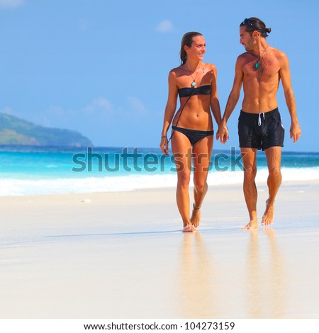 https://thumb7.shutterstock.com/display_pic_with_logo/295900/104273159/stock-photo-young-couple-walking-on-a-sandy-beach-along-a-coastline-104273159.jpg