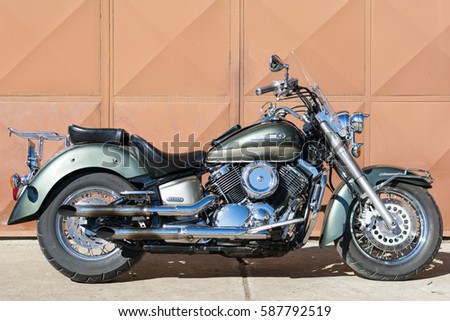 Subotica, Serbia-February 25,2017:Green Yamaha DragStar 1100 motorcycle in front of the garage, photographed on a nice sunny day. Ready for restoration. Lot of chrome detail.