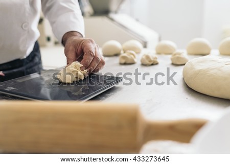 Baker kneading dough in a bakery. Bakery Concept.