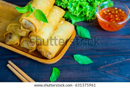 closeup deep fried spring rolls in wooden tray with sauce place on black table