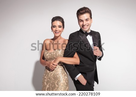 http://thumb7.shutterstock.com/display_pic_with_logo/305215/220278109/stock-photo-elegant-couple-laughing-for-the-camera-while-holding-arm-to-arm-on-grey-background-220278109.jpg