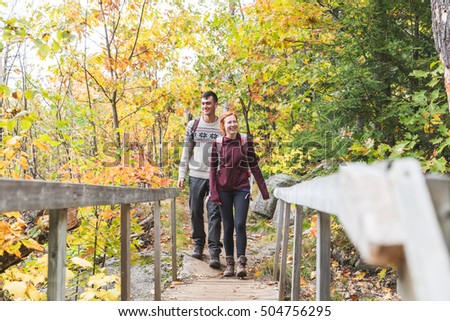 https://thumb7.shutterstock.com/display_pic_with_logo/308011/504756295/stock-photo-couple-hiking-in-the-woods-two-happy-young-people-walking-over-a-wooden-bridge-with-colourful-504756295.jpg