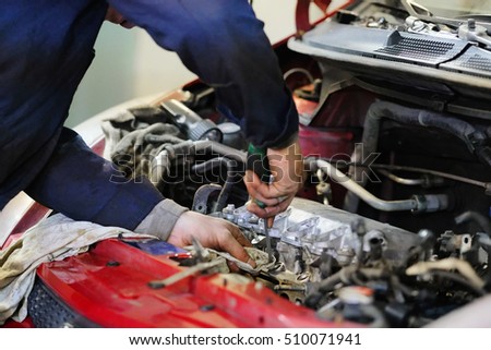 Worker repairs a car in a car repair center