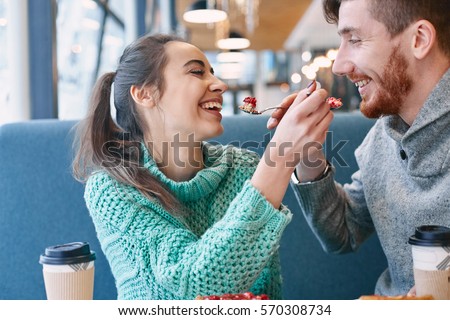 https://thumb7.shutterstock.com/display_pic_with_logo/309106/570308734/stock-photo-couple-eating-a-dessert-in-a-cafe-on-a-date-and-drinking-coffee-woman-and-man-looks-at-a-spoon-570308734.jpg