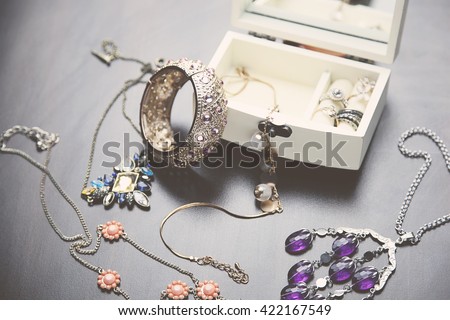 A collection of vintage jewelry in antique wooden jewelry box