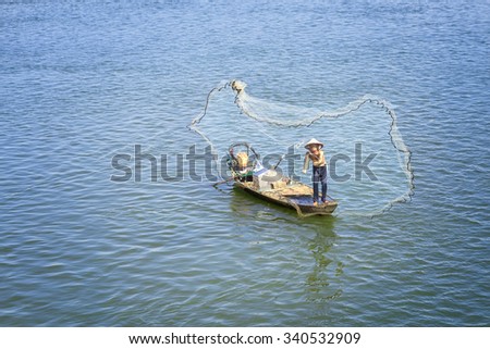 In Dong Nai, Vietnam - November 15th, 2015: The fishermen casting their nets to catch the fish survive better improve the lives winter morning at Tri An, Dong Nai, Vietnam