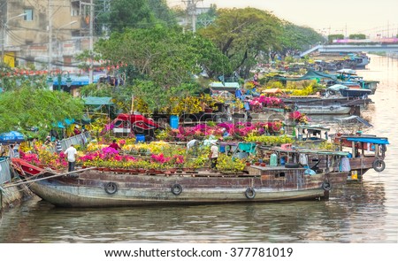Ho Chi Minh City, Vietnam - February 6th, 2016: boating along canal carry flowers with apricot, confetti, almond tree to sell everyone distillation welcome spring Tet in Ho Chi Minh City, Vietnam