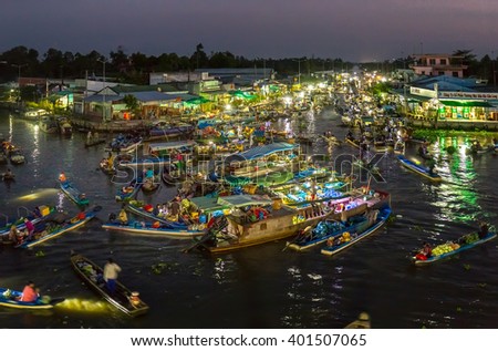 Soc Trang, Vietnam - February 3rd, 2016: Landscape dawn river floating market with busy night boats lights twinkling night agricultural goods to trade in preparation New Year in Soc Trang, Vietnam