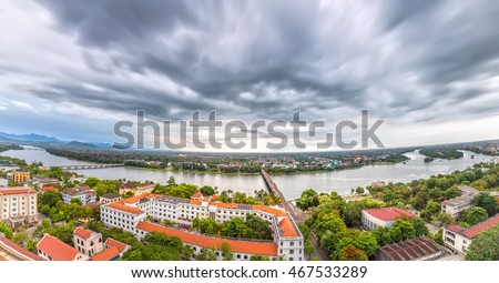 Hue, Vietnam - June 21st, 2015: Panorama city in afternoon with billowing clouds when storm comes, below ancient red tile house as urban areas along river beautiful and idyllic in Hue, Vietnam