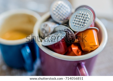 Coffee And Used Pods In Enamel Mugs Against Wooden Background Coffee And Used Pods In Enamel Mugs Against Wooden Background