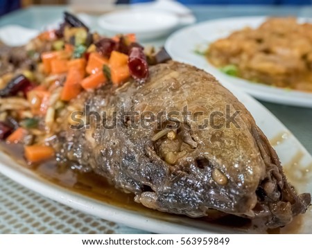 Braised Yellow Croaker fish or Corvina - Beijing-style. The fish is fried and then braised with a spicy sauce containing diced carrots and chopped dried chilli.