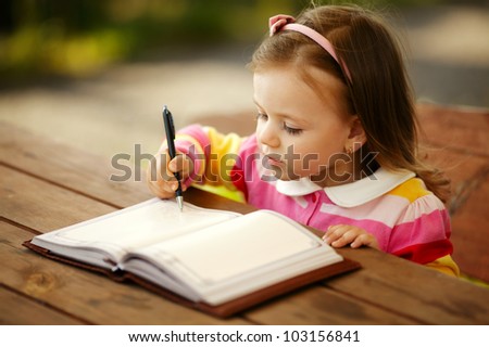 little girl writes to the notepad