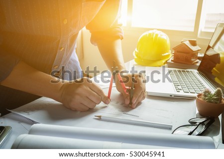 Architect working on blueprint.engineer inspective in workplace - architectural project, blueprints,ruler,calculator,laptop and divider compass. Construction concept. Engineering tools,selective focus