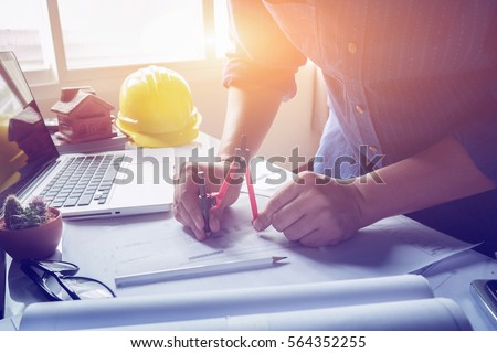 Architect working on blueprint. Architects workplace - architectural project, blueprints, ruler, calculator, laptop and divider compass. Construction concept. Engineering tools,selective focus