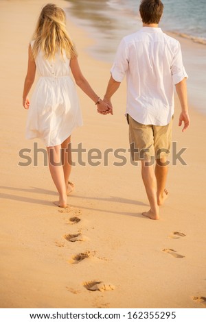 https://thumb7.shutterstock.com/display_pic_with_logo/322021/162355295/stock-photo-romantic-couple-holding-hands-walking-on-beach-at-sunset-man-and-woman-in-love-footprints-in-the-162355295.jpg