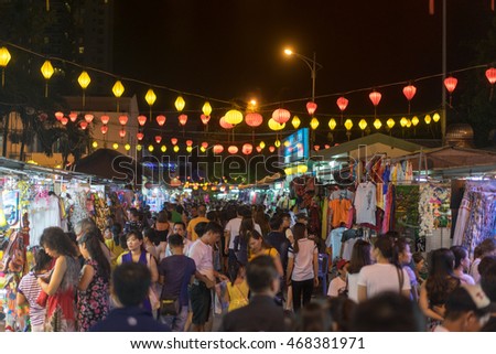 NHA TRANG, VIETNAM - JUNE 19, 2016: People are walking on the night illuminated market street in the touristic zone in Vietnam