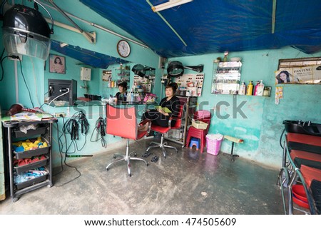 NHA TRANG, VIETNAM - JUNE 23, 2016: Empty beauty shop in Vietnam. The hairdresser is sitting in a chair.