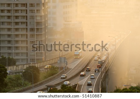 Air pollution scenic with cars on highway and yellow smoke in city.