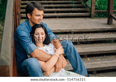 https://thumb7.shutterstock.com/display_pic_with_logo/3297746/514756315/stock-photo-young-pretty-happy-couple-sitting-on-wooden-stairs-in-the-park-man-and-woman-dating-and-flirting-514756315.jpg