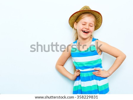 laughing child girl portrait on white background. yellow hat . fashion style posing.