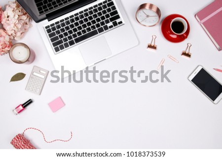 Feminine desk workspace frame with pink beige floral bouquet, red coffee cup, smartphone accessories and notebook on white background with copy space. Flat lay. Top view. Valentines day background.