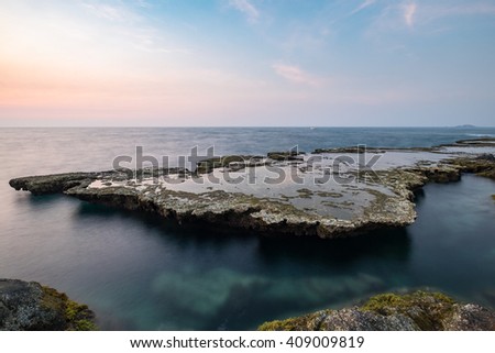 Wonderful dawn over large rock in calm waves at Nui Chua national park, Ninh Thuan Province, Viet Nam, one of amazing landscape in Vietnam, masterpiece place for travel.