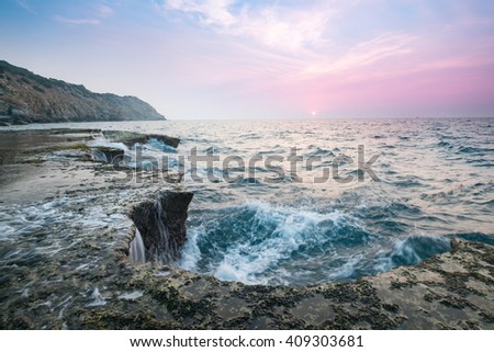 Wonderful dawn over large rock in calm waves at Nui Chua national park, Ninh Thuan Province, Viet Nam, one of amazing landscape in Vietnam, masterpiece place for travel.