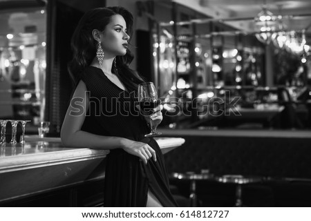 stock photo gorgeous beauty young brunette woman in dark dress with glass of wine standing at the bar in luxury 614812727
