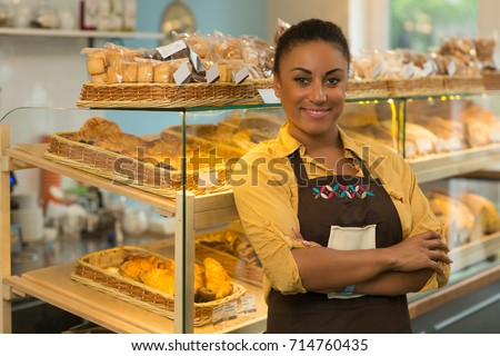 Cheerful African mature woman smiling joyfully posing proudly with her arms folded at her bakery store copyspace baker job occupation businesswoman salesperson retailer professional confidence success