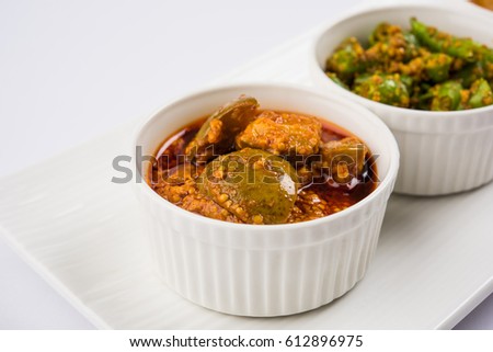 Group photograph of indian pickles like mango pickle , lemon pickle and green chilli pickle, sarved in white ceramic bowl, selective focus