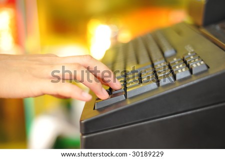 Woman's hand on cash register buttons