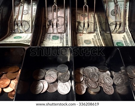 American dallar notes and coins inside the cash register machine