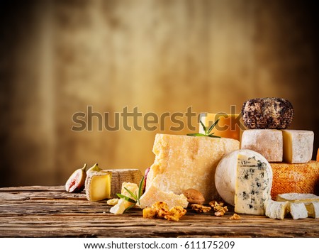 Various kind of cheese served on wooden table, traditional pieces of french and italy hand-made cheese. Copyspace for text