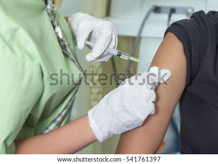 Hospital interior for background. Close-up hands,nurses are vaccinations to patients using the syringe.Doctor vaccinating women in hospital.Are treated by the use of sterile injectable upper arm.