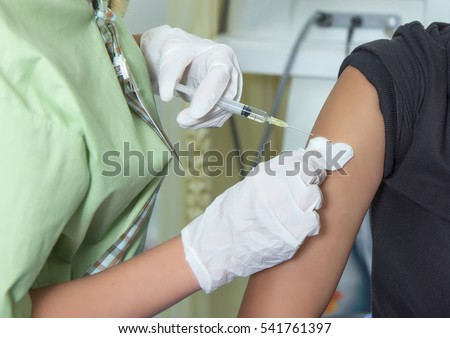 Interior do hospital para segundo plano.  Mãos fechadas, enfermeiras são vacinadas para pacientes que usam a seringa. Médico vacinando mulheres no hospital. São tratadas com o uso de braço injetável estéril.
