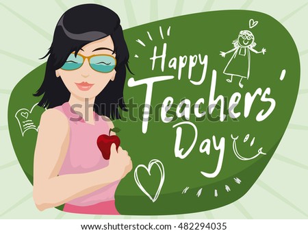 Smiling young female educator celebrating Teachers' Day in the classroom with a student's drawings as gift for her.