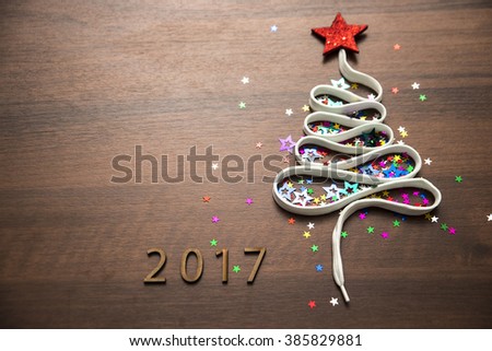 Sigh symbol Christmas Tree from a lot colorful confetti, lace and red star toy on old retro vintage style wooden texture background Empty copy space for inscription Idea of merry new year 2017 holiday
